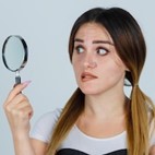 Young woman holding magnifying glass