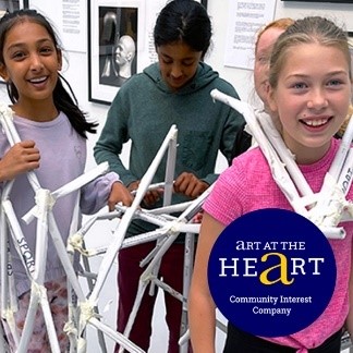 A group of girls holding a structure made of white sticks